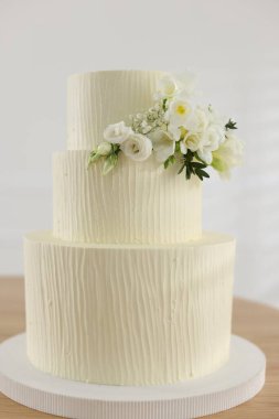 İçerideki ahşap masada çiçek desenli nefis düğün pastası.