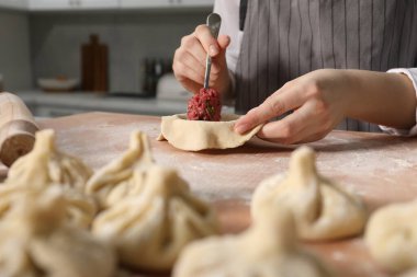 Mutfaktaki masada khinkali yapan kadın, yakın plan.