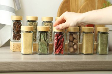 Kapalı alanda kırmızı biberli kavanoz alan bir kadın.