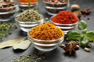 Gri masada farklı aromatik baharatlar, yakın plan.