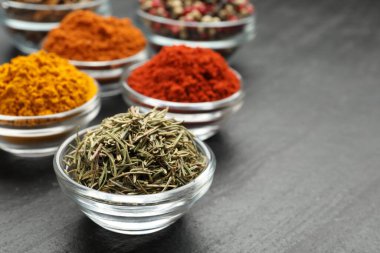 Gri masada farklı aromatik baharatlar, yakın plan.