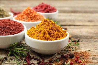 Ahşap masada farklı aromatik baharatlar, yakın plan.