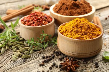 Ahşap masada farklı aromatik baharatlar, yakın plan.