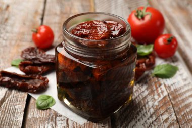 Lezzetli, kurutulmuş domatesler ve taze sebzeler ahşap masada, yakın plan.