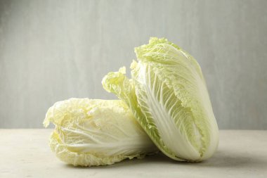 Açık gri masada taze Çin lahanaları, yakın plan.