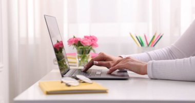 Ev ofisteki dizüstü bilgisayarda çalışan kadın, yakın plan.