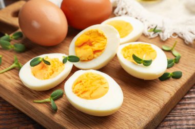 Tahta masanın üzerinde mikro yeşillikli haşlanmış yumurtalar, yakın plan.