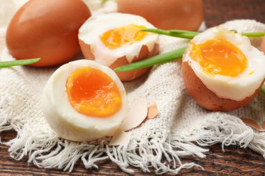 Ahşap masada yeşil soğanlı kaynamış yumurta, yakın plan.