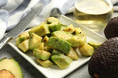 Gri desenli masada soslu lezzetli avokadolar, yakın plan.