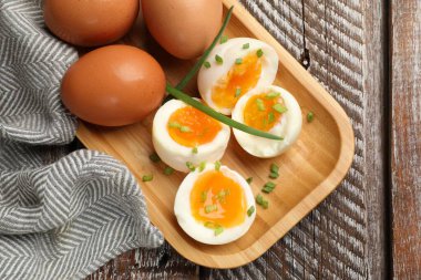 Ahşap masada yeşil soğanlı kaynamış yumurta, üst manzara.