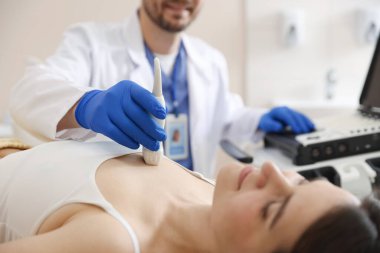 Kadın kalbinin ultrason muayenesini klinikte yapan sonograf.