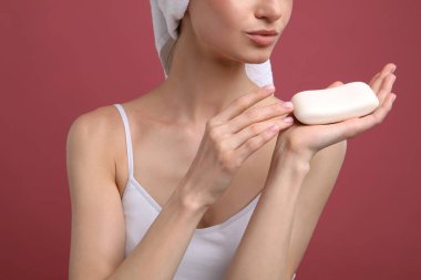 Pembe arka planda sabun barı olan kadın, yakın plan.