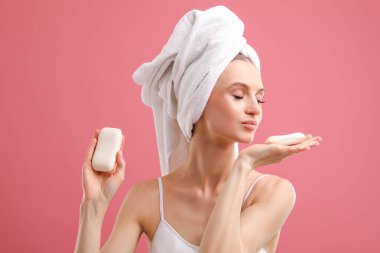 Pembe arka planda sabun çubukları olan güzel bir kadın.