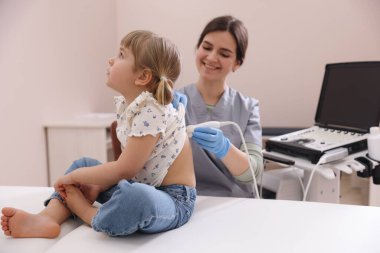 Küçük kızın ultrason muayenesini klinikte yapan bir sonograf.