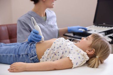 Sonograf, klinikte küçük bir kızın karın ultrasonu muayenesi yapıyor.