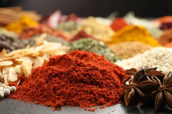 Gri masada farklı aromatik baharatlar, yakın plan.