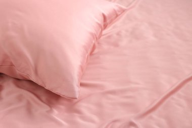 Güzel pembe ipek çarşaflı yatak, yakın plan. Metin için boşluk