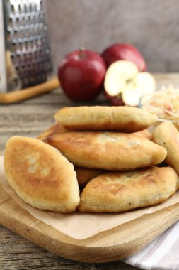 Lezzetli kızarmış pirinçler (doldurulmuş turtalar) ve ahşap masada elmalar, yakın plan.