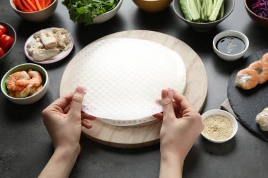 Koyu gri masada nefis börek yapan kadın, yakın plan.