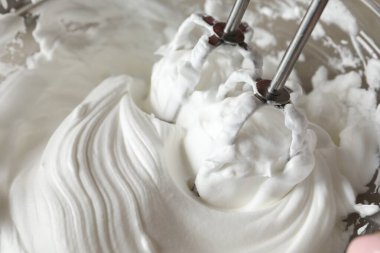 Kaymaklı çırpma kremi kasede, yakın plan.