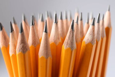Açık gri arkaplanda keskin grafit kalemler, yakın plan