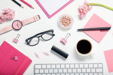 Kırtasiye malzemesi, kahve ve çiçeklerle bembeyaz arka planda düz kompozisyon