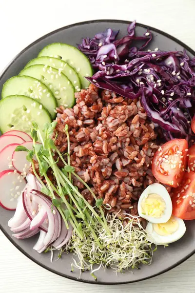 Beyaz masada kahverengi pirinçli lezzetli bir salata.