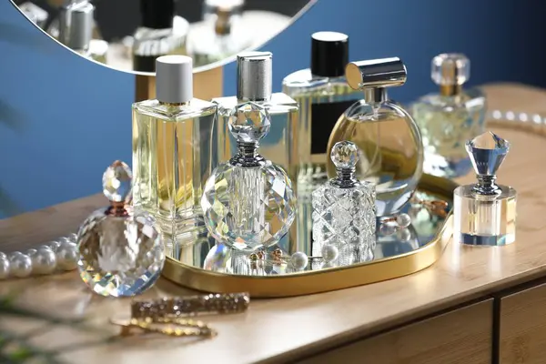 İçerideki ahşap masada parfüm şişeleri.