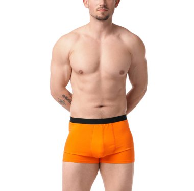 Beyaz arka planda turuncu iç çamaşırlı genç adam, yakın plan.