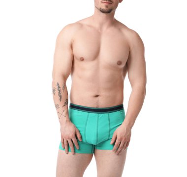 Beyaz arka planda şık turkuaz iç çamaşırlı genç adam, yakın plan.