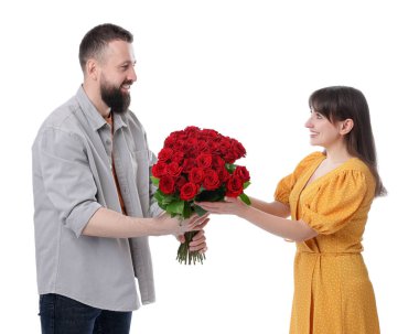 Adam beyaz arka planda sevgilisine kırmızı gül buketi sunuyor.