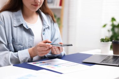 Ofisteki masada akıllı telefondan tarama uygulaması kullanarak belgenin fotoğrafını çeken bir kadın. Metin için boşluk