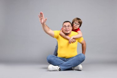 Baba ve oğlu gri arka planda, mesaj için yer var.