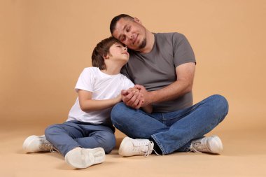 Babası ve oğlu bej arka planda.