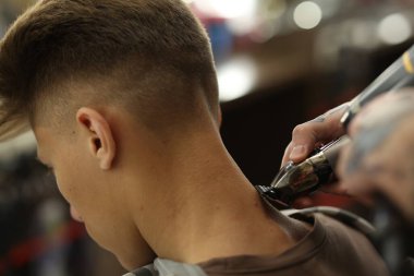 Profesyonel berber berber dükkanında şık saç kesimi yapıyor, yakın plan.