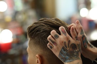 Berber dükkanında müşteriyle çalışan profesyonel berber, yakın plan.