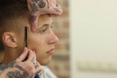 Berber dükkanında müşteriyle çalışan profesyonel berber, yakın plan. Metin için boşluk