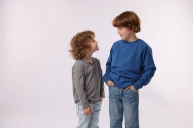 Beyaz arka planda poz veren şirin küçük kardeşler.