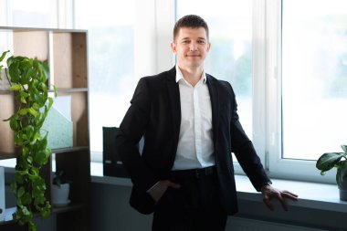 Pencerenin yanındaki yakışıklı adamın portresi.