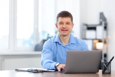 Ofisteki masada dizüstü bilgisayarda çalışan bir adam. Metin için boşluk