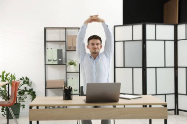 Ofiste sandalyeye uzanan yakışıklı adam.