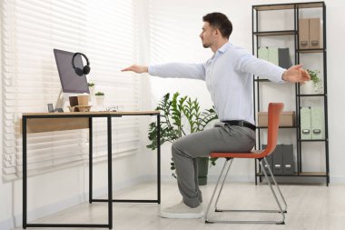 Ofiste sandalyeye uzanan yakışıklı adam.