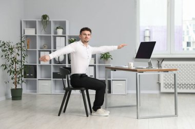 Ofiste sandalyeye uzanan yakışıklı adam.