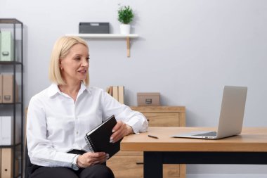 Masasında not defteri olan profesyonel bir psikolog.