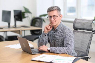 Ofisteki laptopta çalışan iş adamının portresi.