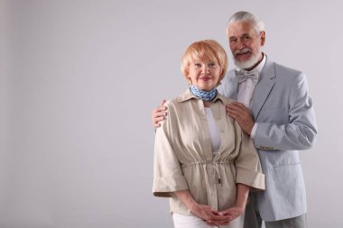 Açık gri arka planda sevimli yaşlı çift, mesaj için alan