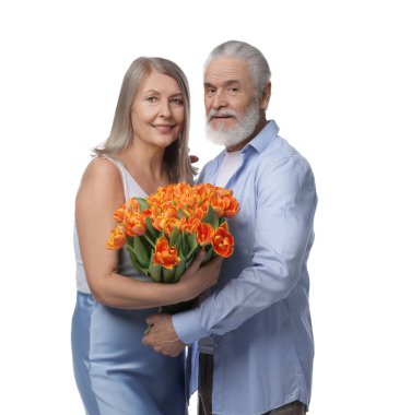 Beyaz arka planda bir buket lale olan mutlu bir çift.