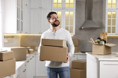 Taşınma günü. Yeni evinde karton kutuları olan bir adam.