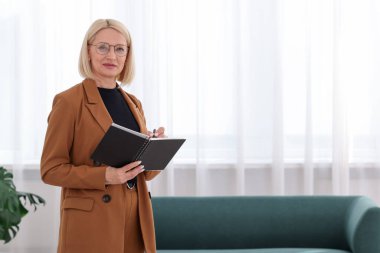 Uzman psikolog, kapalı mekanda deftere yazı yazıyor, metin için boşluk var.