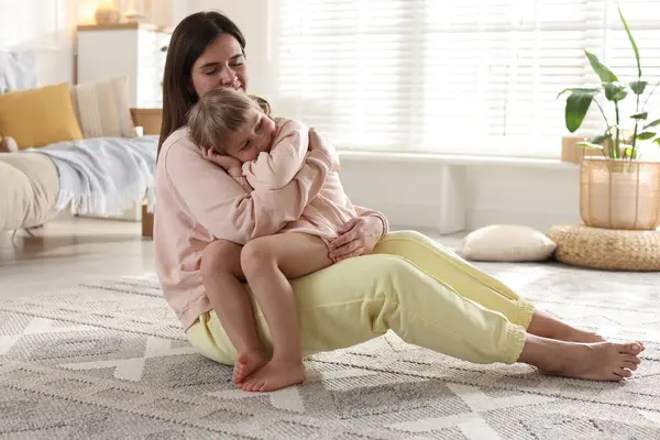 Mutlu anne ve tatlı kızı evde yerde yatıyor.